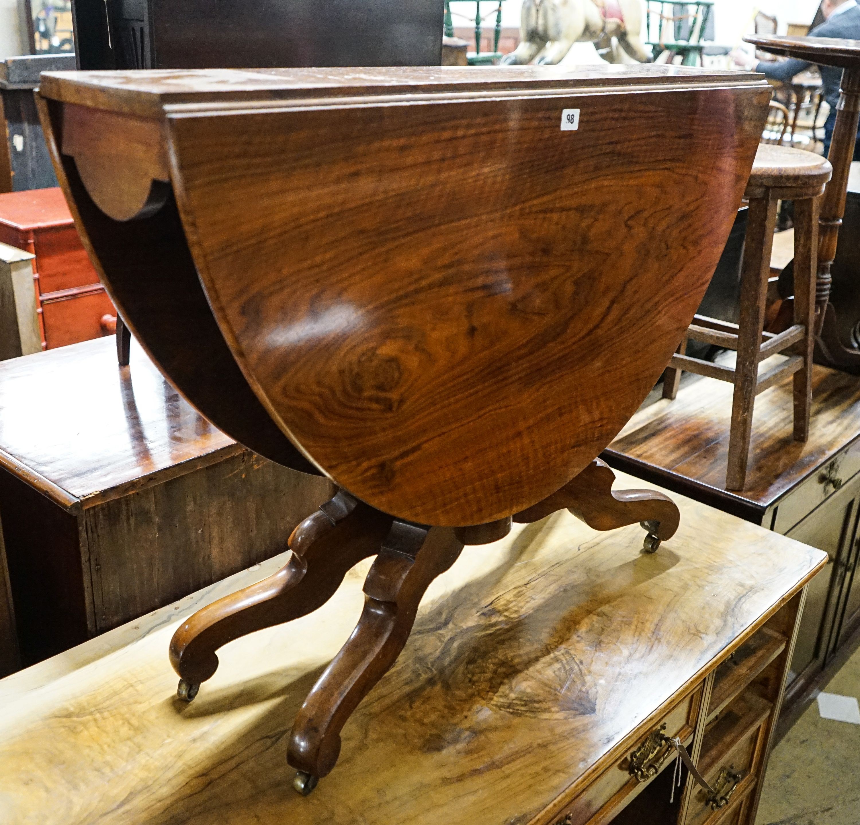 A Victorian figured walnut oval Sutherland table on turned supports and quadripartite scrolled legs, 118cm extended, width 100cm, height 73cm